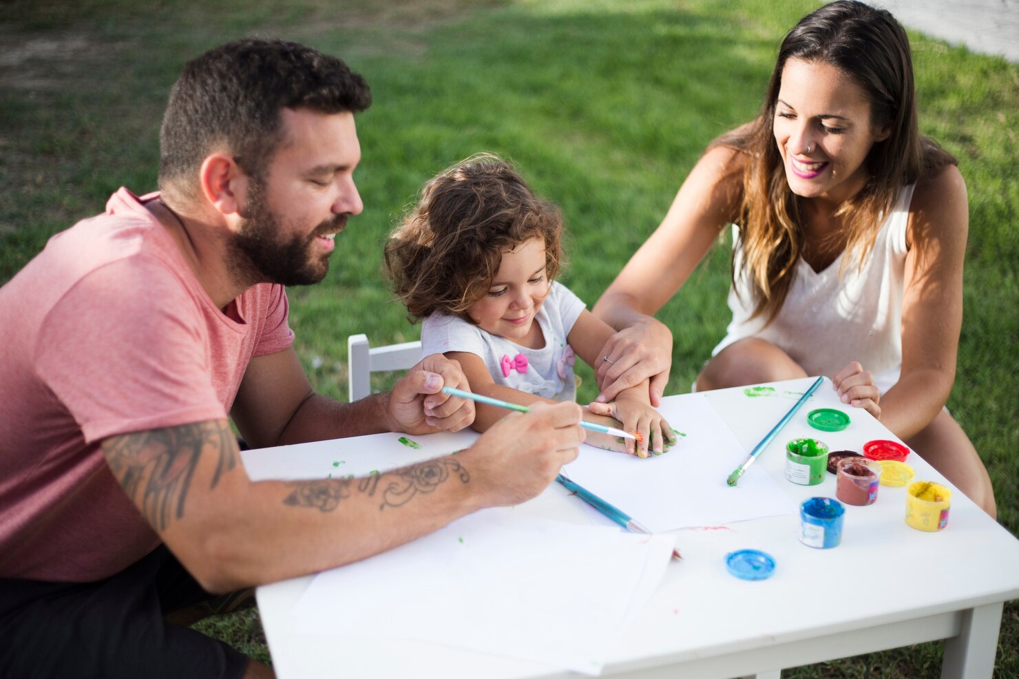 padres-su-hija-pintando-juntos-parque
